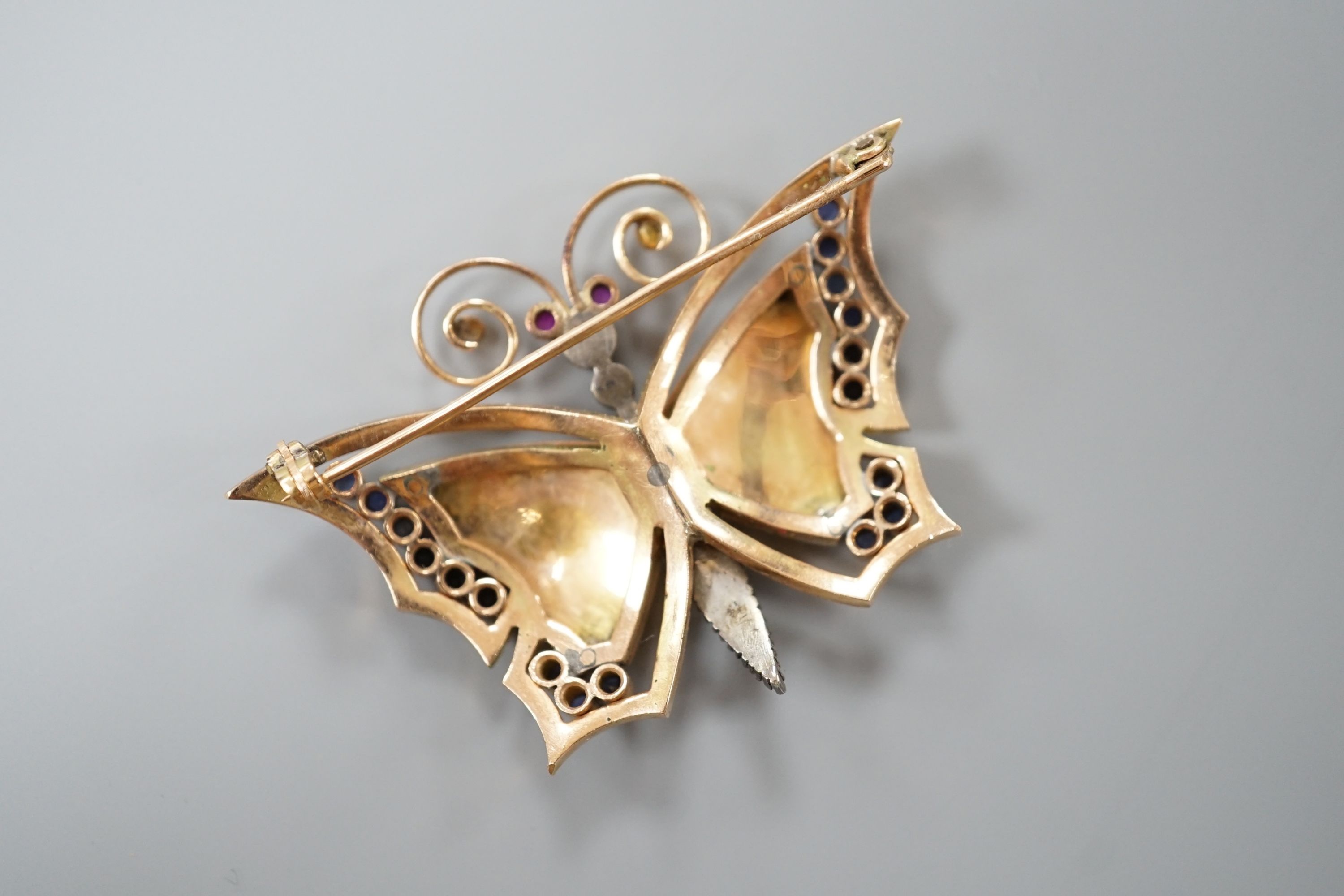 A continental yellow metal, polychrome enamel, rose cut diamond and gem set butterfly brooch (a.f.), width 50mm, gross weight 13.8 grams.